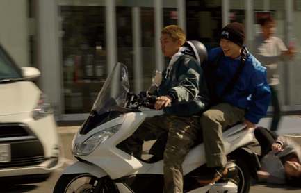 Deux jeunes à scooter dans la rue