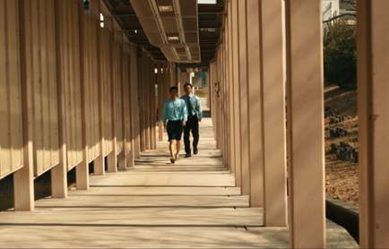 Deux silhouettes au bout d'une galerie couverte